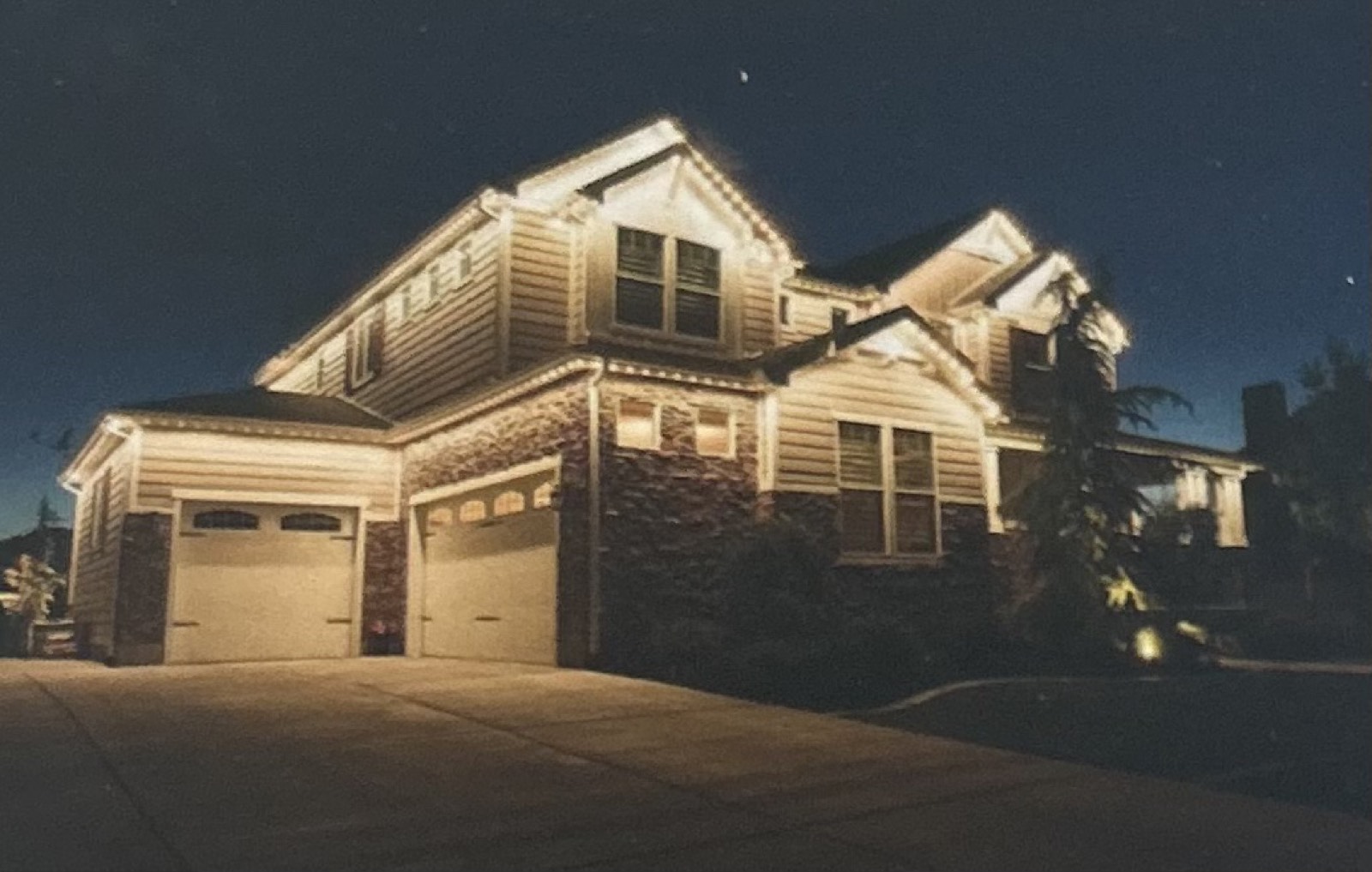 Holiday roofline lights on a home at night